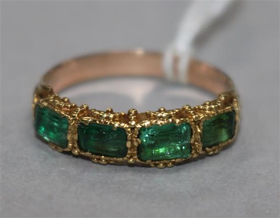 A yellow metal and four stone emerald half hoop ring (one stone replaced?), size N.